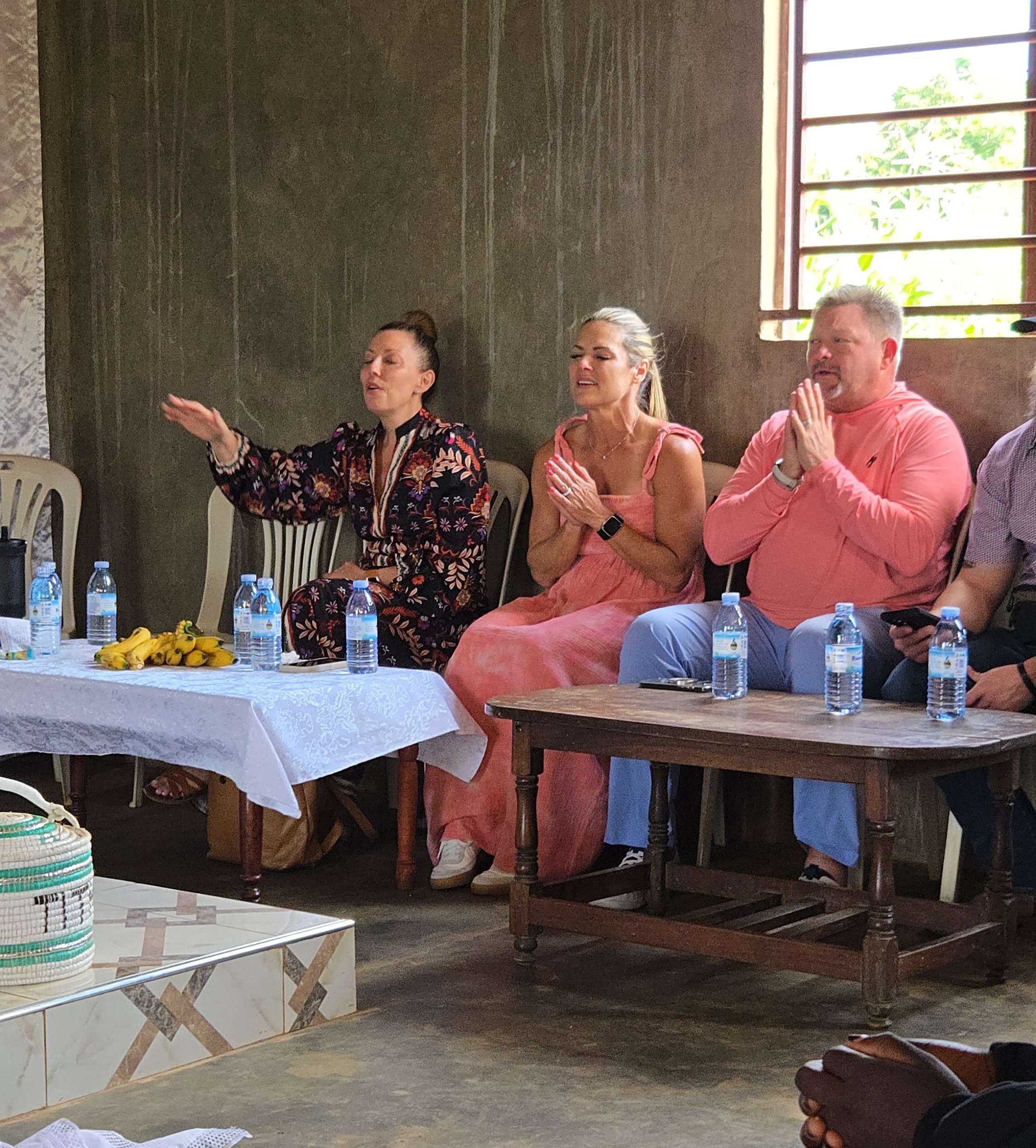 Mission trip members praying together during a gathering in Uganda.