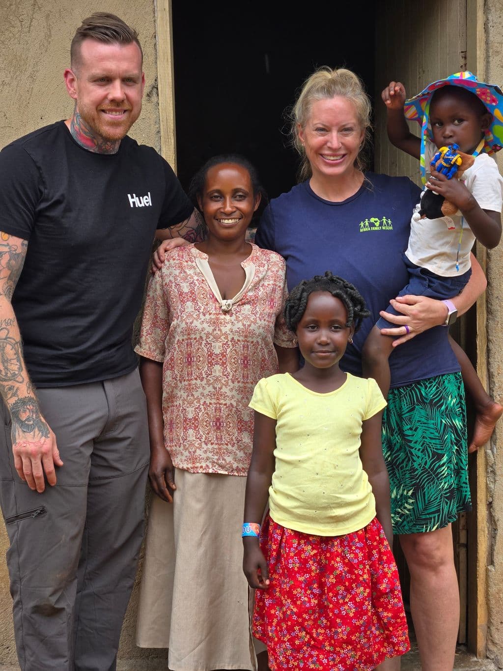 AFR sponsors visiting a family outside their home in Uganda.