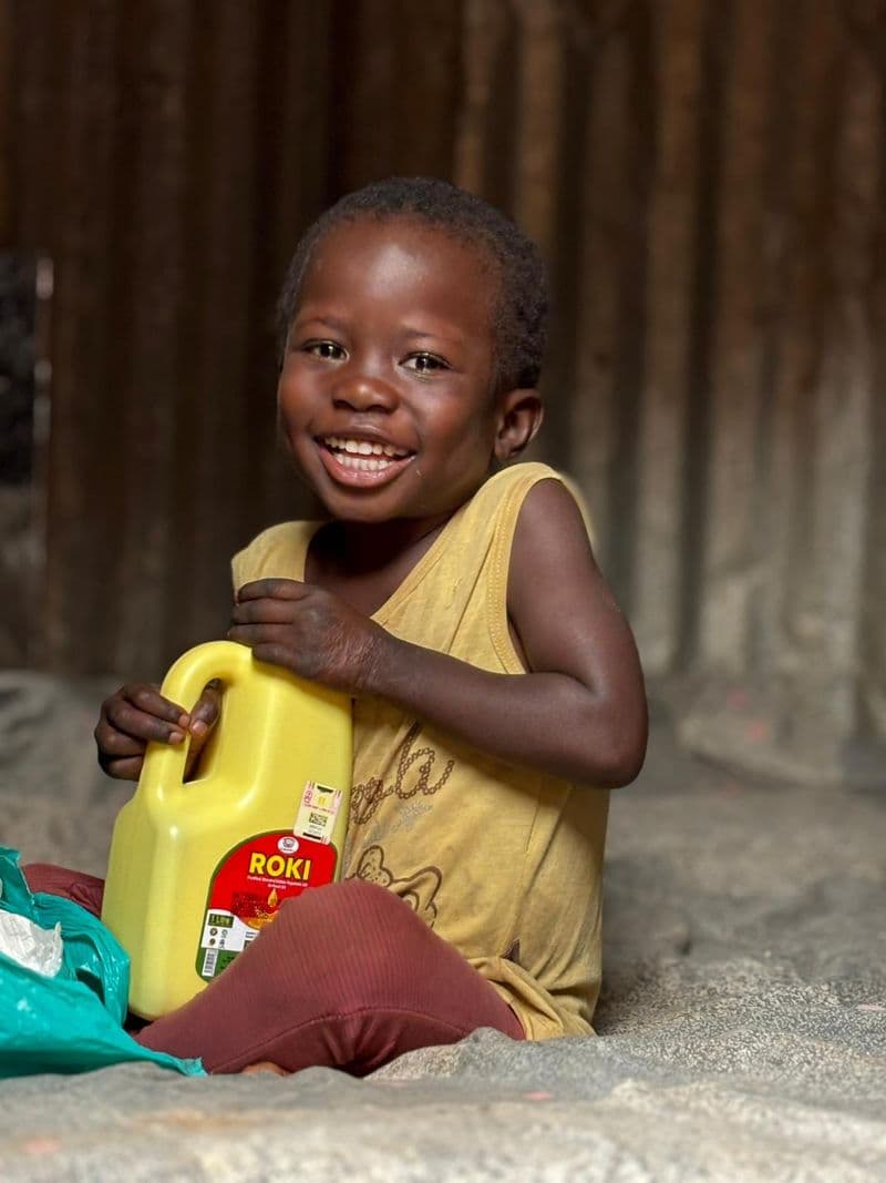 A child smiling during an Africa Family Rescue family visit in Uganda.